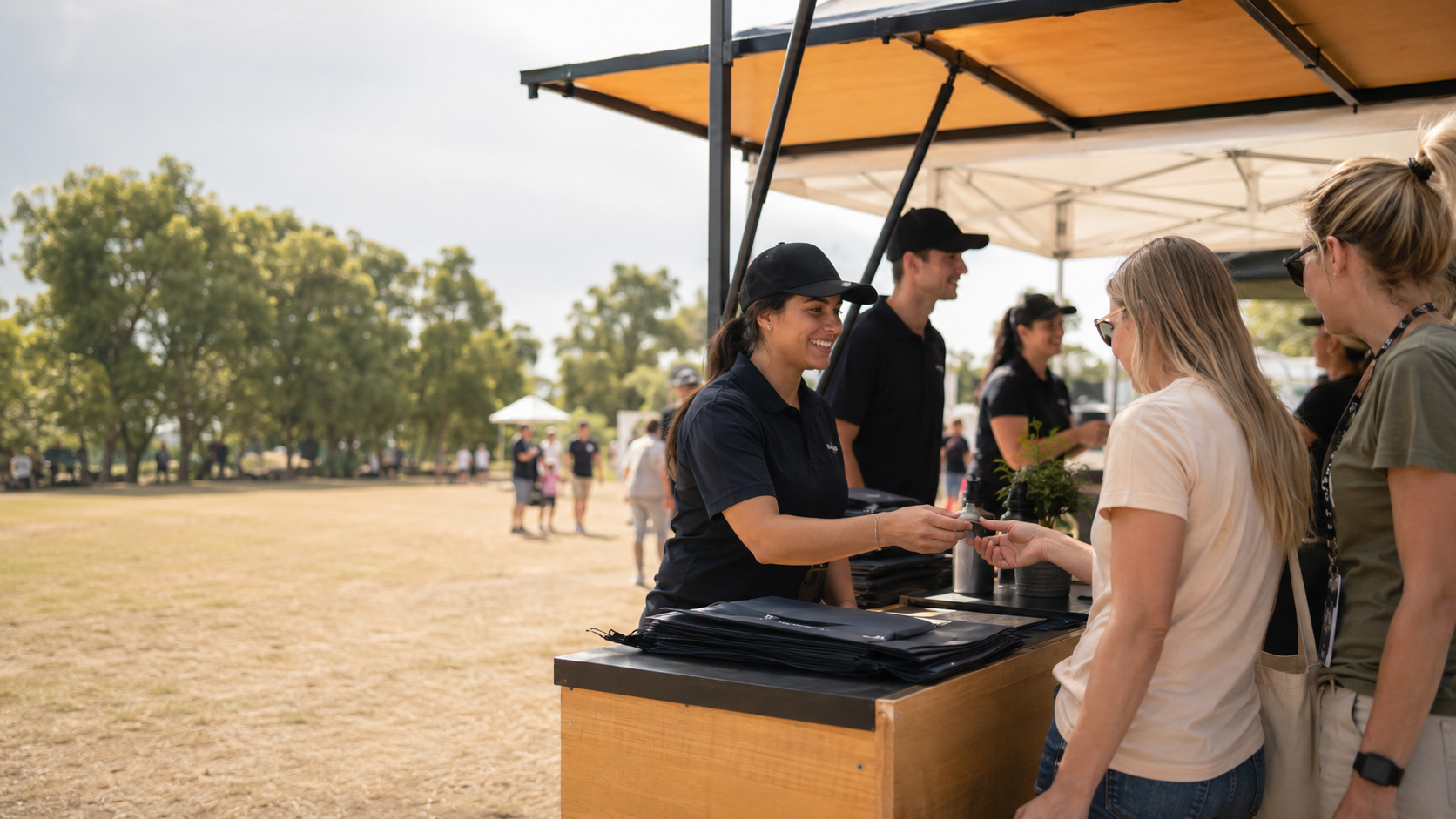 Outdoor event booth with staff helping visitors